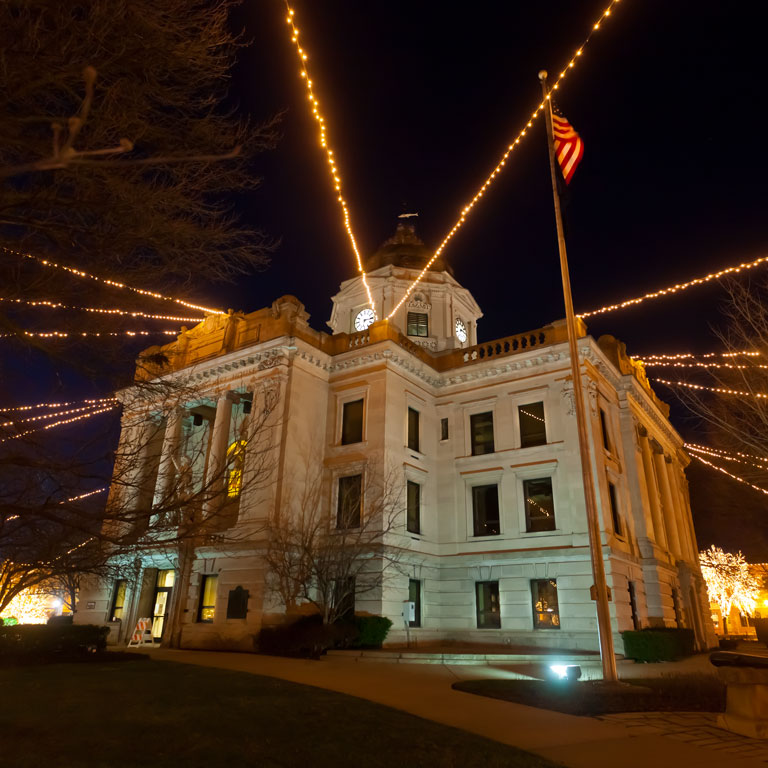 Holiday lights extending from the courthouse at night.